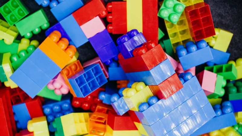 Sterta kolorowych plastikowych klocków: czerwonych, niebieskich, zielonych i żółtych