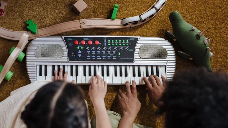 Dzieci grają na plastikowym keyboardzie z kolorowymi przyciskami