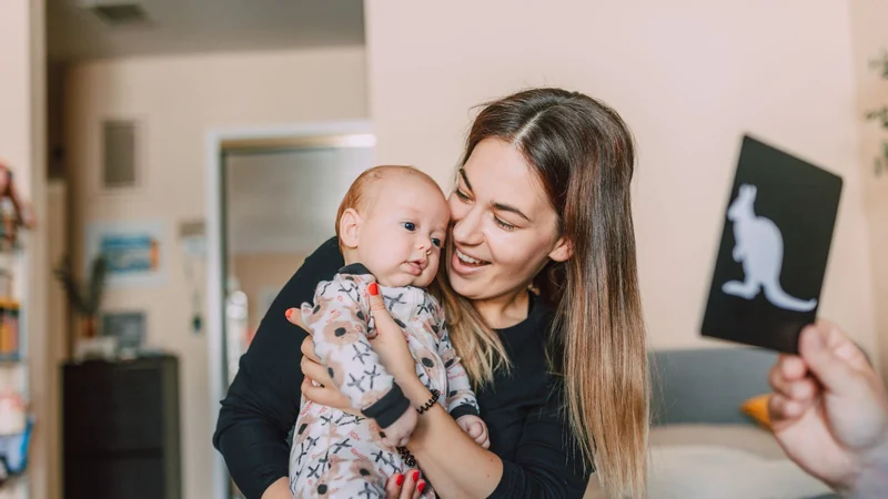 Mama pokazuje niemowlęciu czarno-białą kartę kontrastową z kangurem